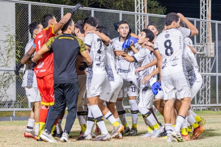 Jogadores de futebol abraçados em comemoração.